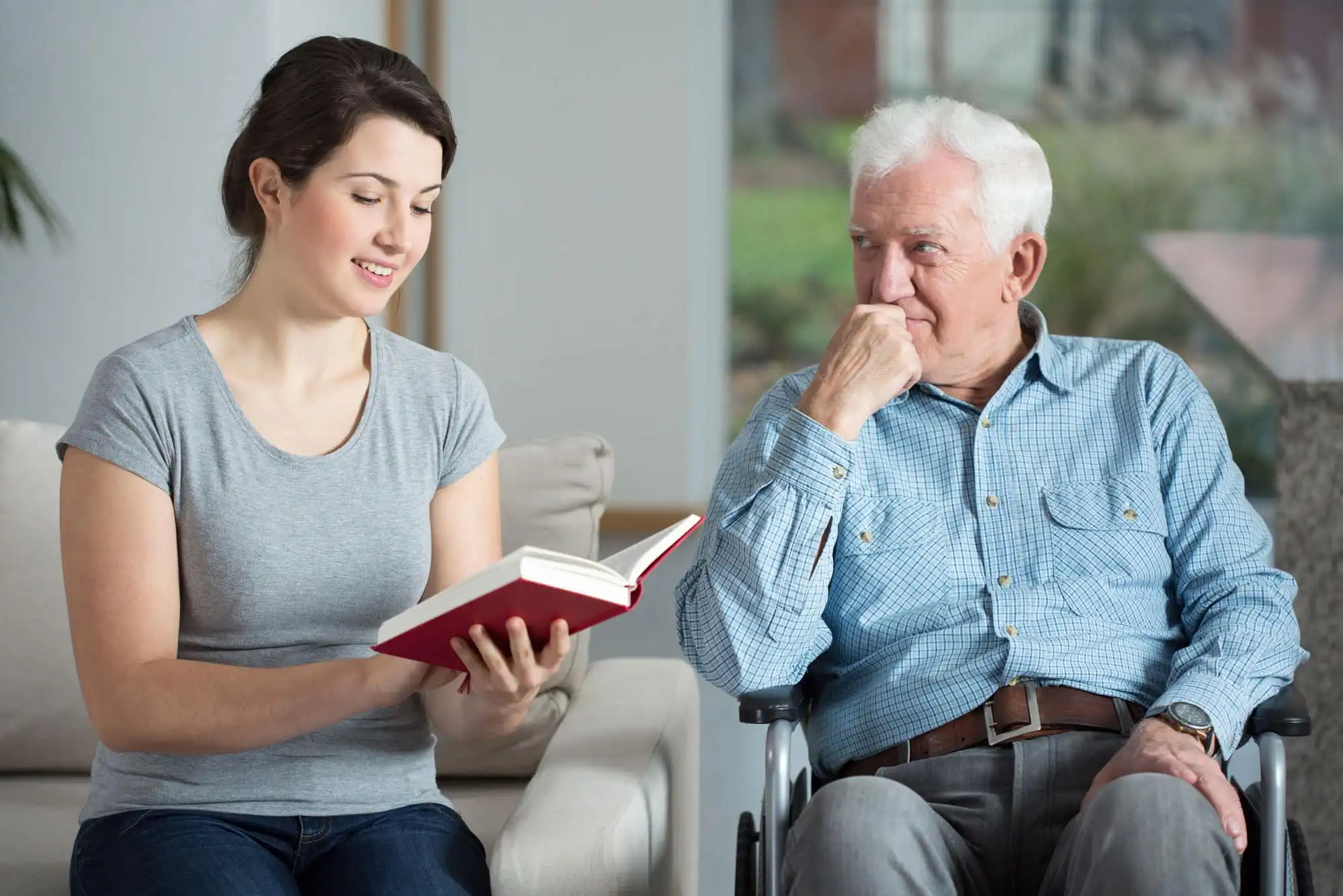 woman reading a book to an old man